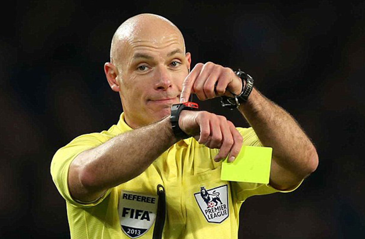 Referee indicating his watch for time.